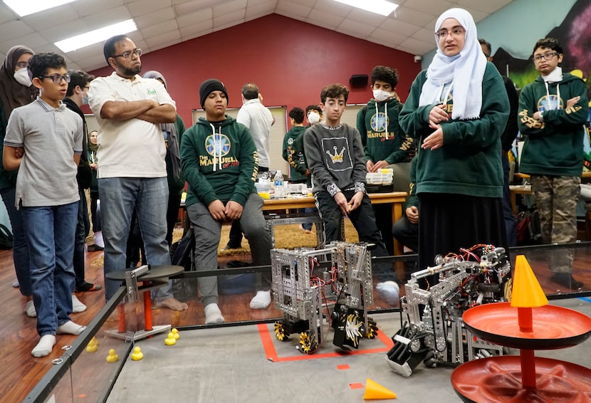 Roofaida Hanoun, 16, speaks to robotics team members about the process of building a robot...