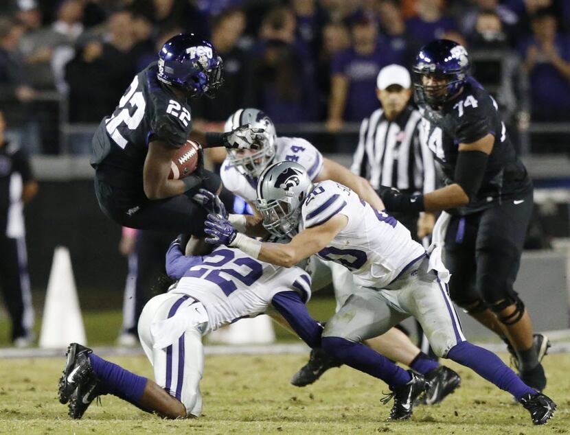 TCU running back Aaron Green (22) is tackled by Kansas State defenders while rushing the...