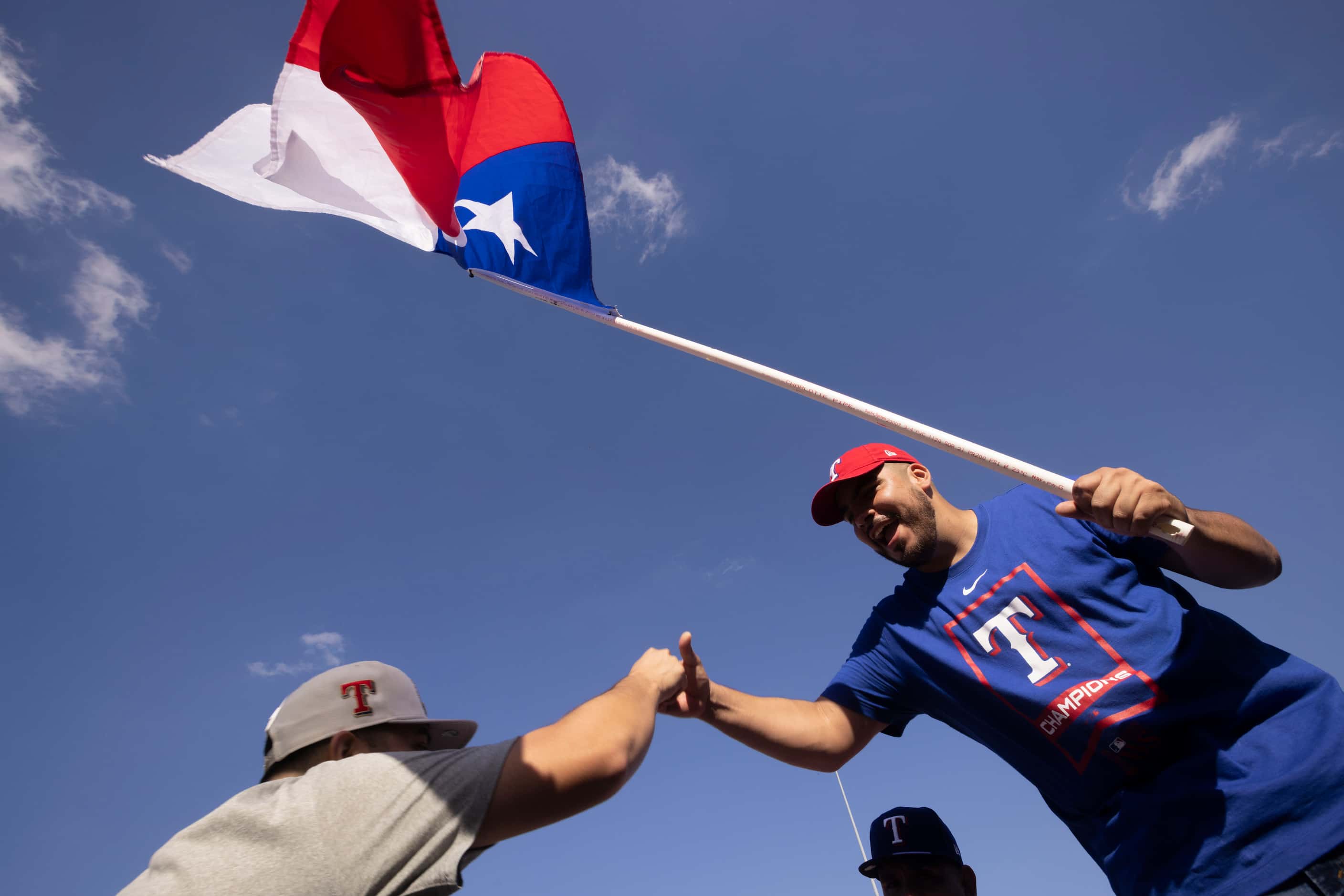 Paul A. Lara of Dallas shakes a fellow fans hand while waving a Texas state flag at Globe...