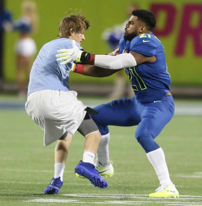 NFC running back Ezekiel Elliott tackles a fan who ran onto the field during the NFL Pro...