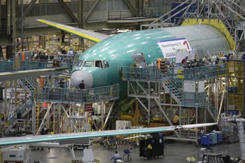Boeing employees work on a 777 jetliner at the production line of the company's plant in...