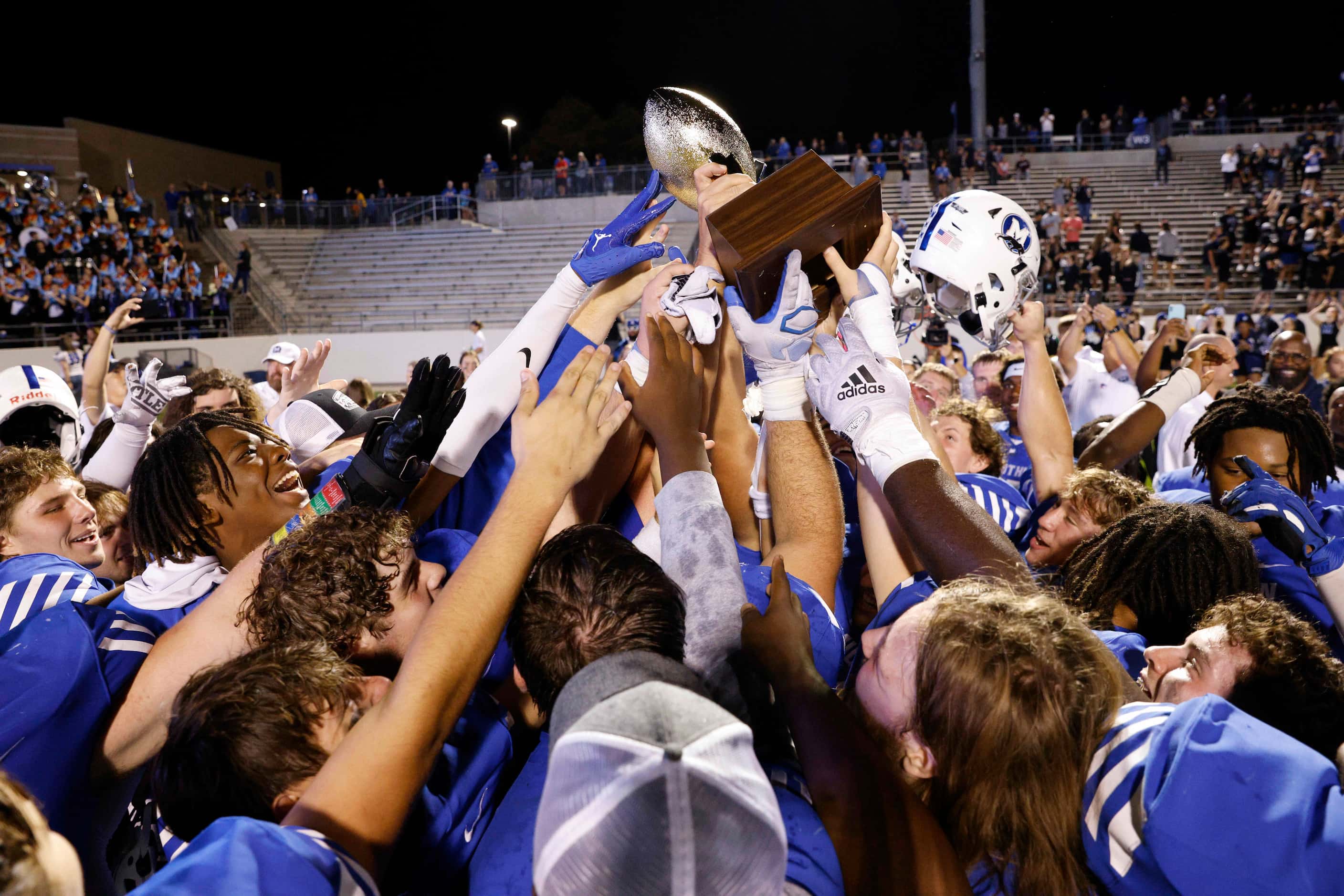 Midlothian players raise the District 4-5A Division I championship trophy after beating Red...