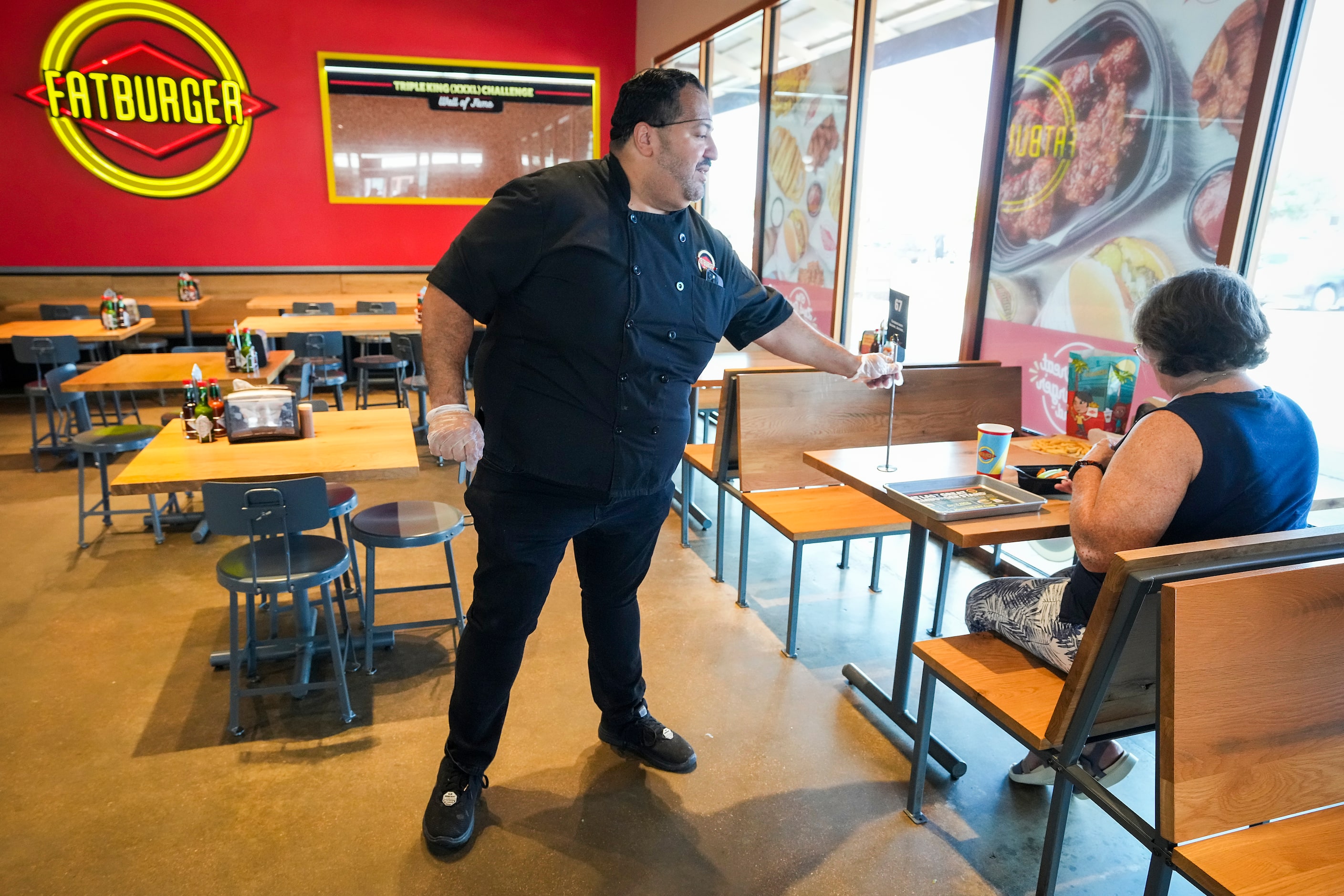 Owner Alf Gonzalez delivers an order to a diner Fatburger at the Allen Premium Outlets on...