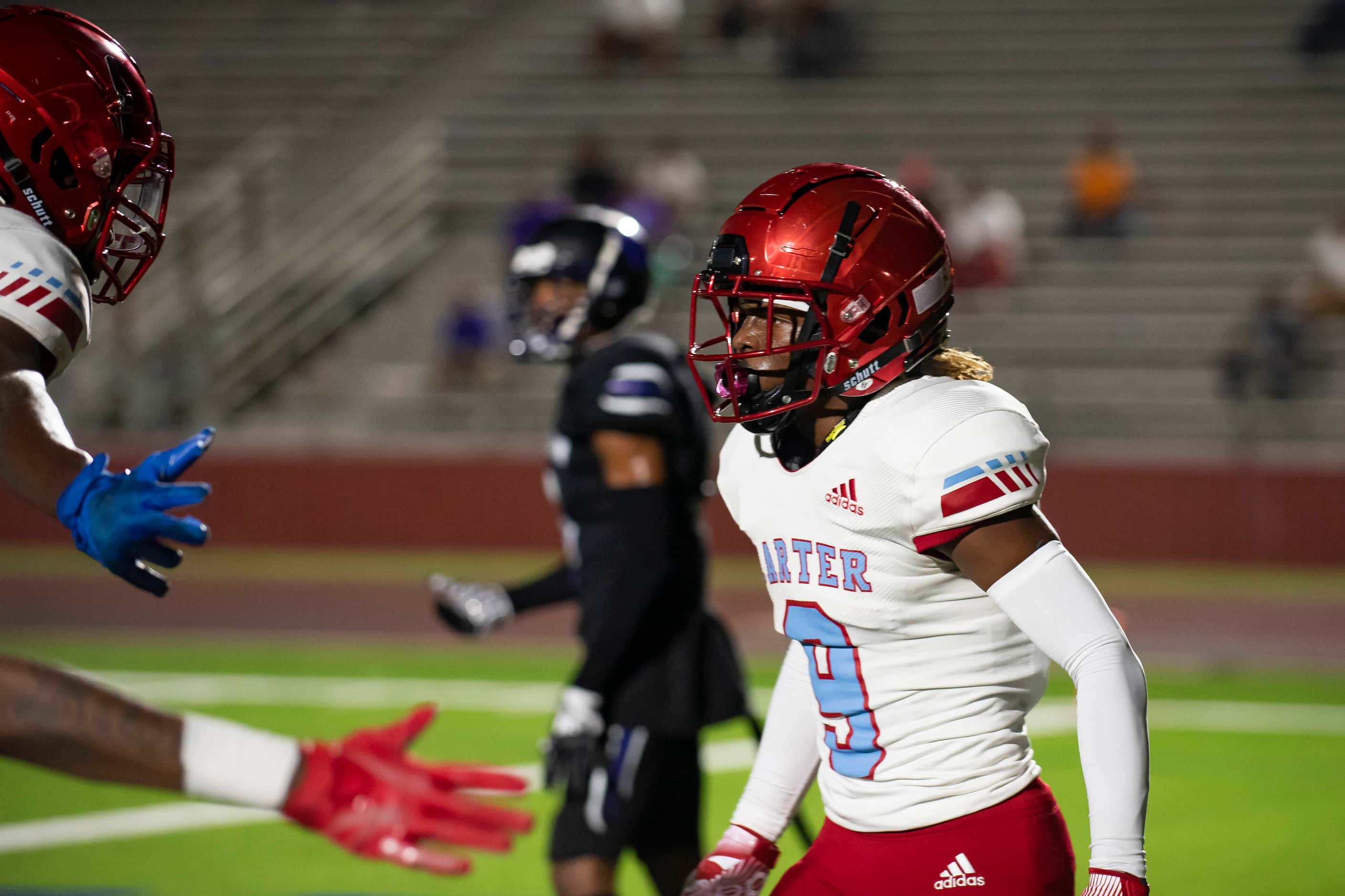 Carter junior Khyion Andrews (9) high fives teammates after catching a touchdown pass in the...