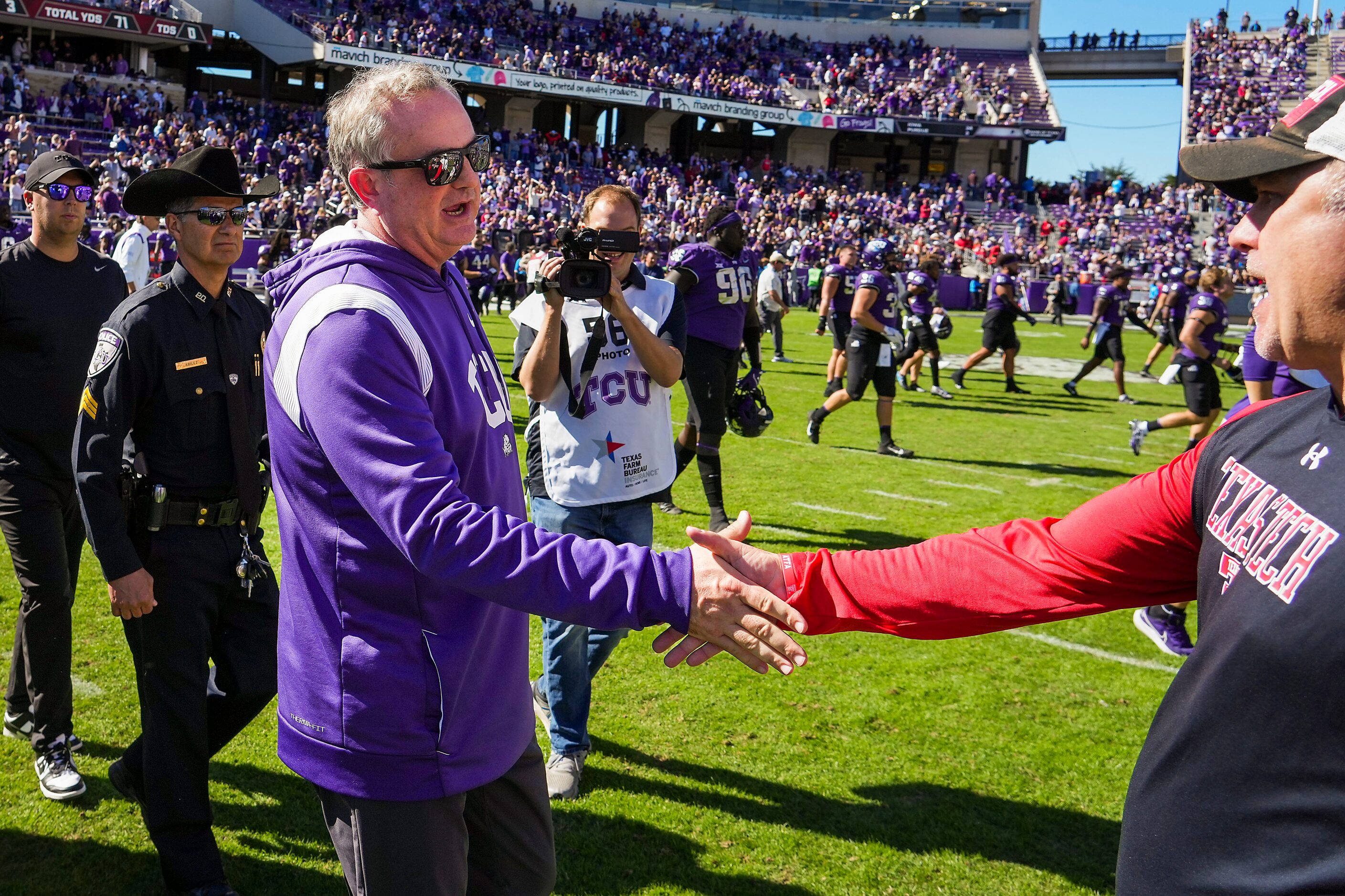 TCU head coach Sonny Dykes  shakes hands with Texas Tech head coach Joey McGuire after  an...