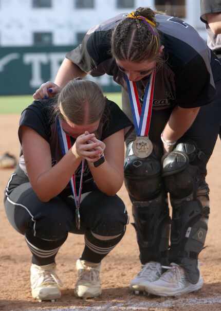 Denton Guyer's Erin Love (15), right, consoles teammate Paige Luzader (11) following the...