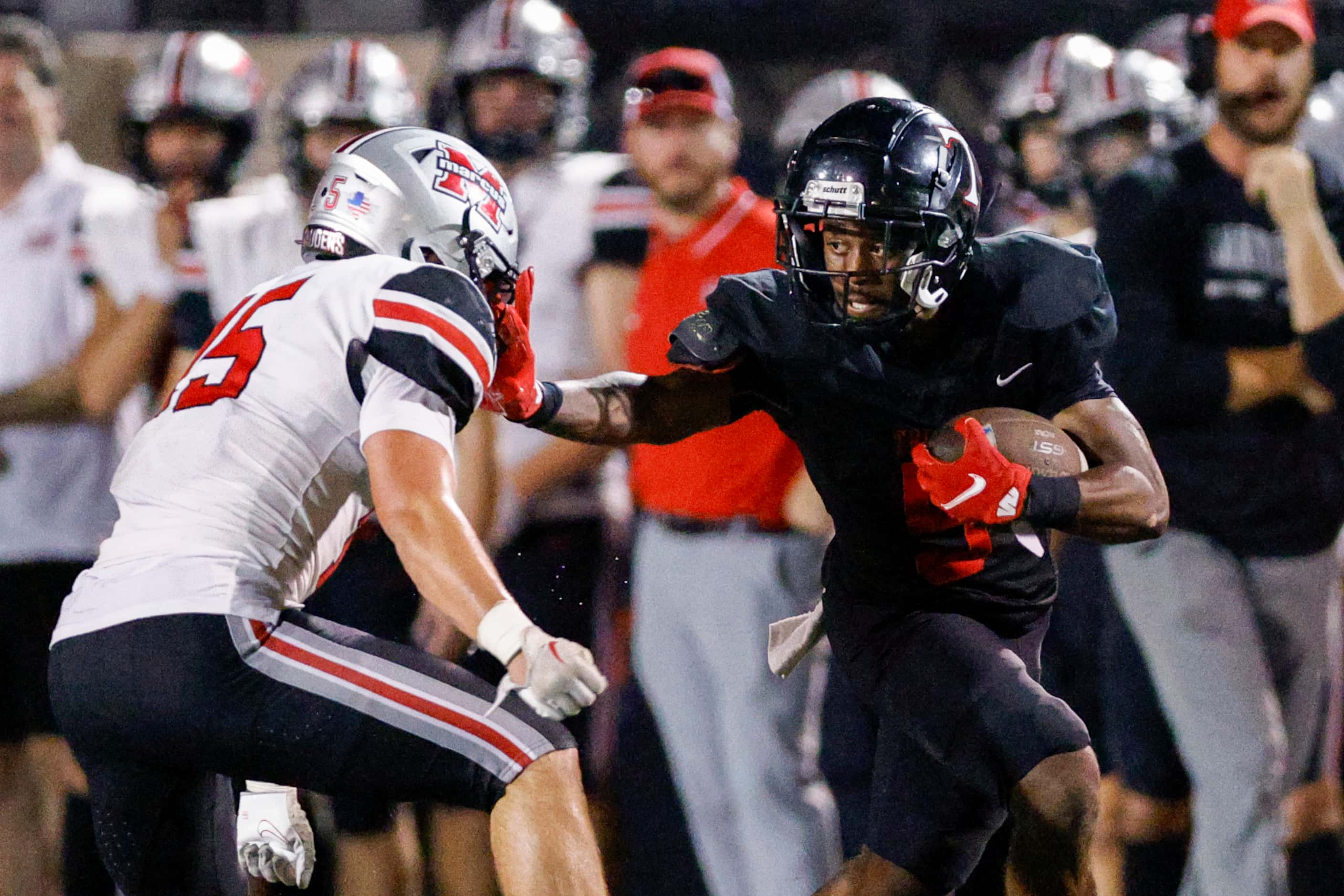 Euless Trinity running back Ethan Wright (5) stiff-arms Flower Mound Marcus’ Brock Golwas...