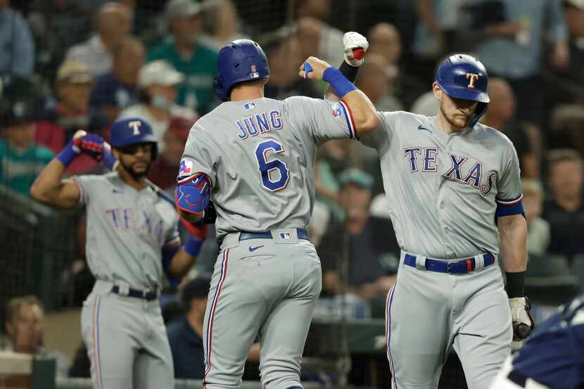 Texas Rangers' Josh Jung is greeted by Sam Huff after hitting a solo home run on a pitch...