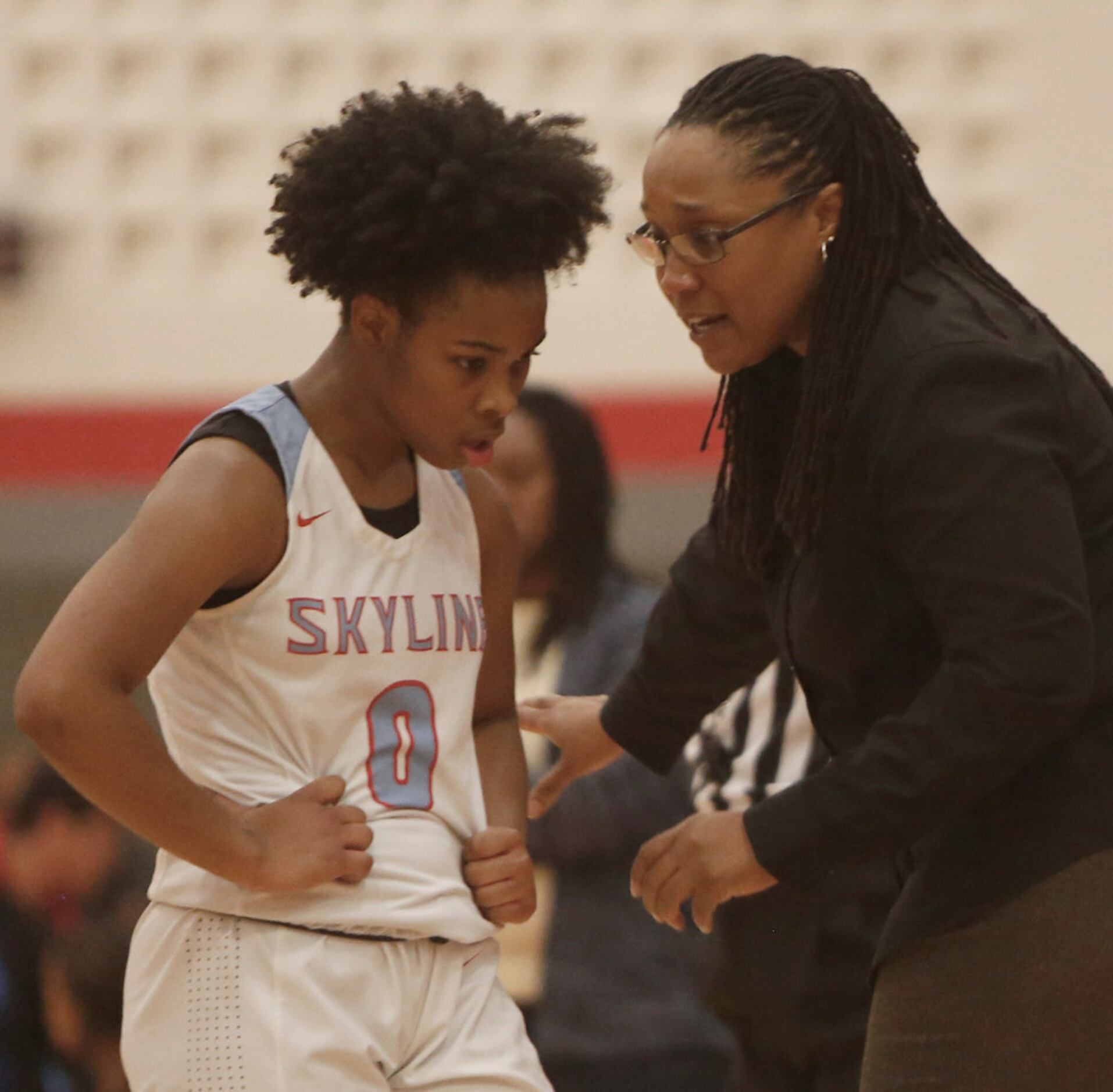 Dallas Skyline head coach Melonie Hopson speaks with Zyniah Thomas (0) in front of the team...