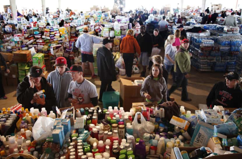 West residents and volunteers sort through donated items at the food and clothing...