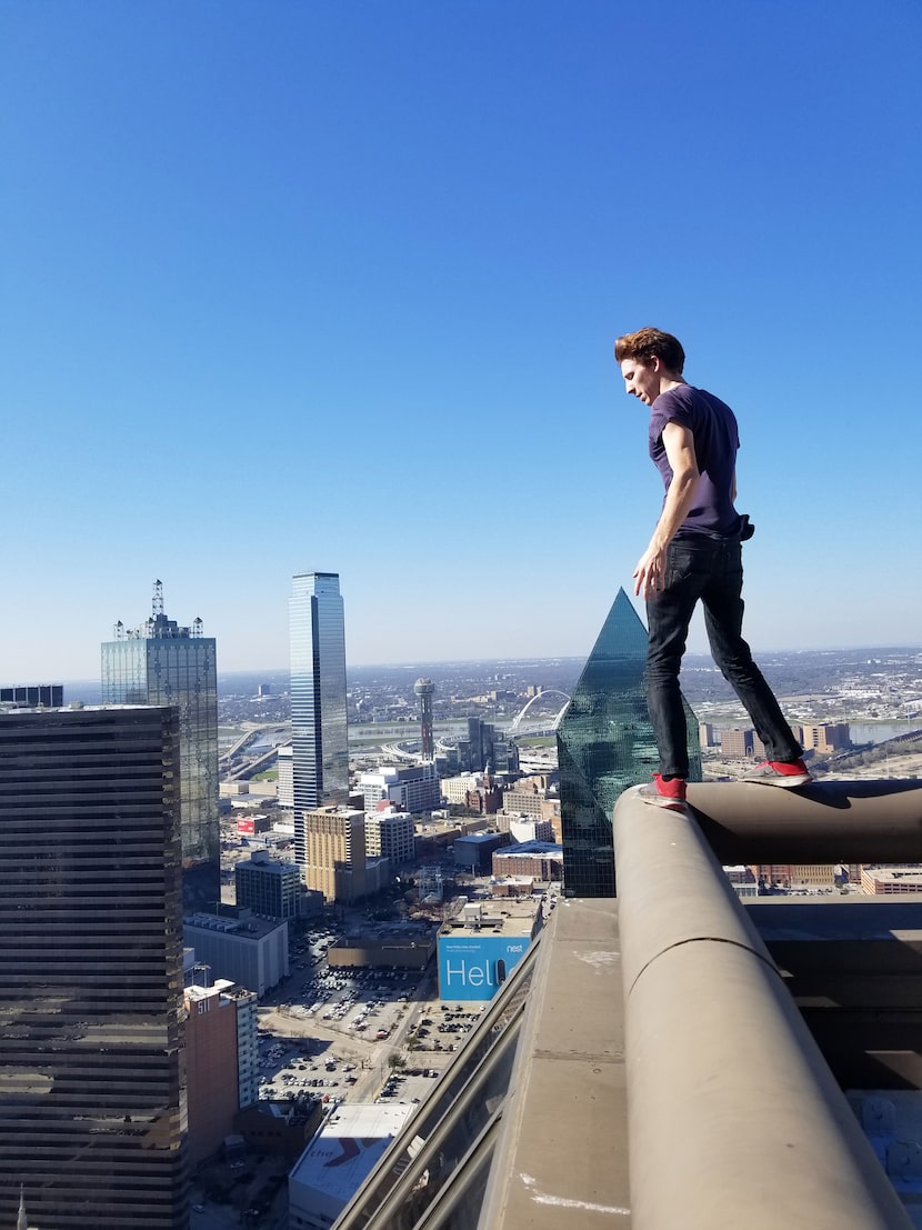 Daniel Dennis, a rooftopper who goes by @_AdventureDan_ on Instagram, balances on the...