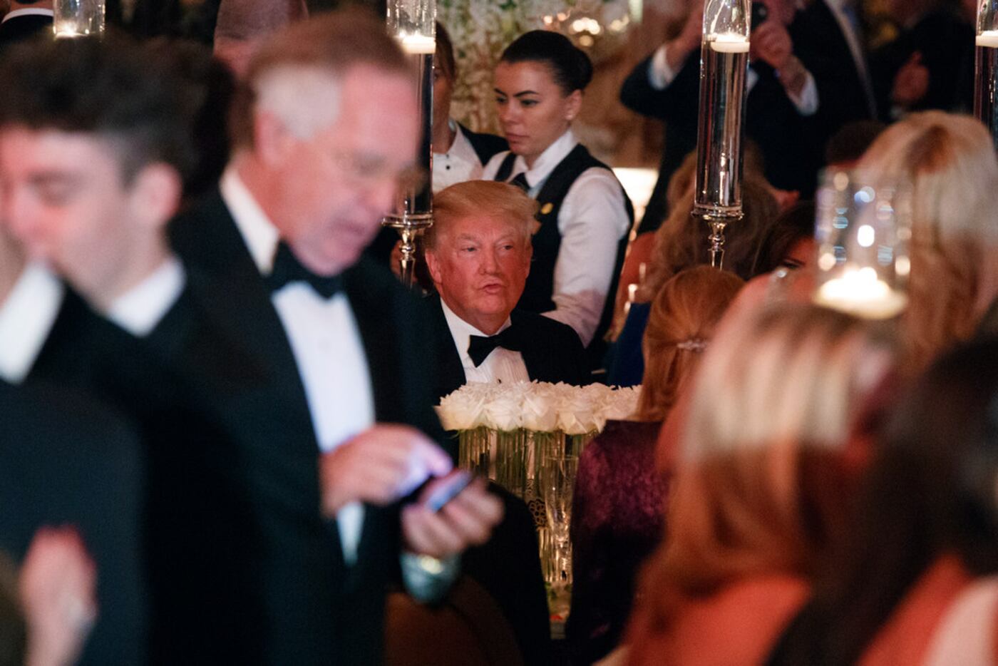 President Donald Trump sits at his table during a New Year's Eve gala at his Mar-a-Lago...
