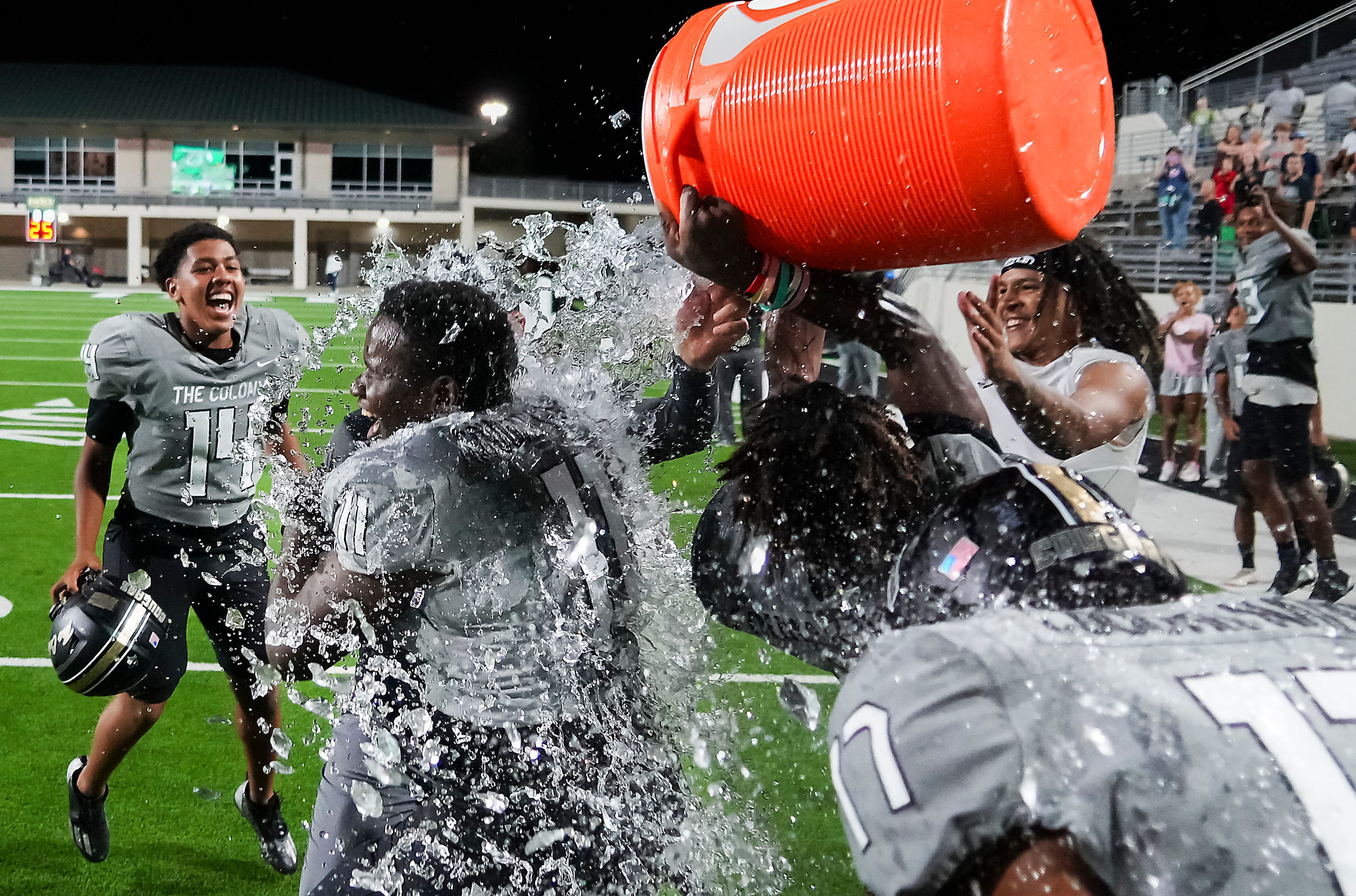 The Colony players douse head coach Rudy Rangel and defensive lineman William Adegbenro (11)...