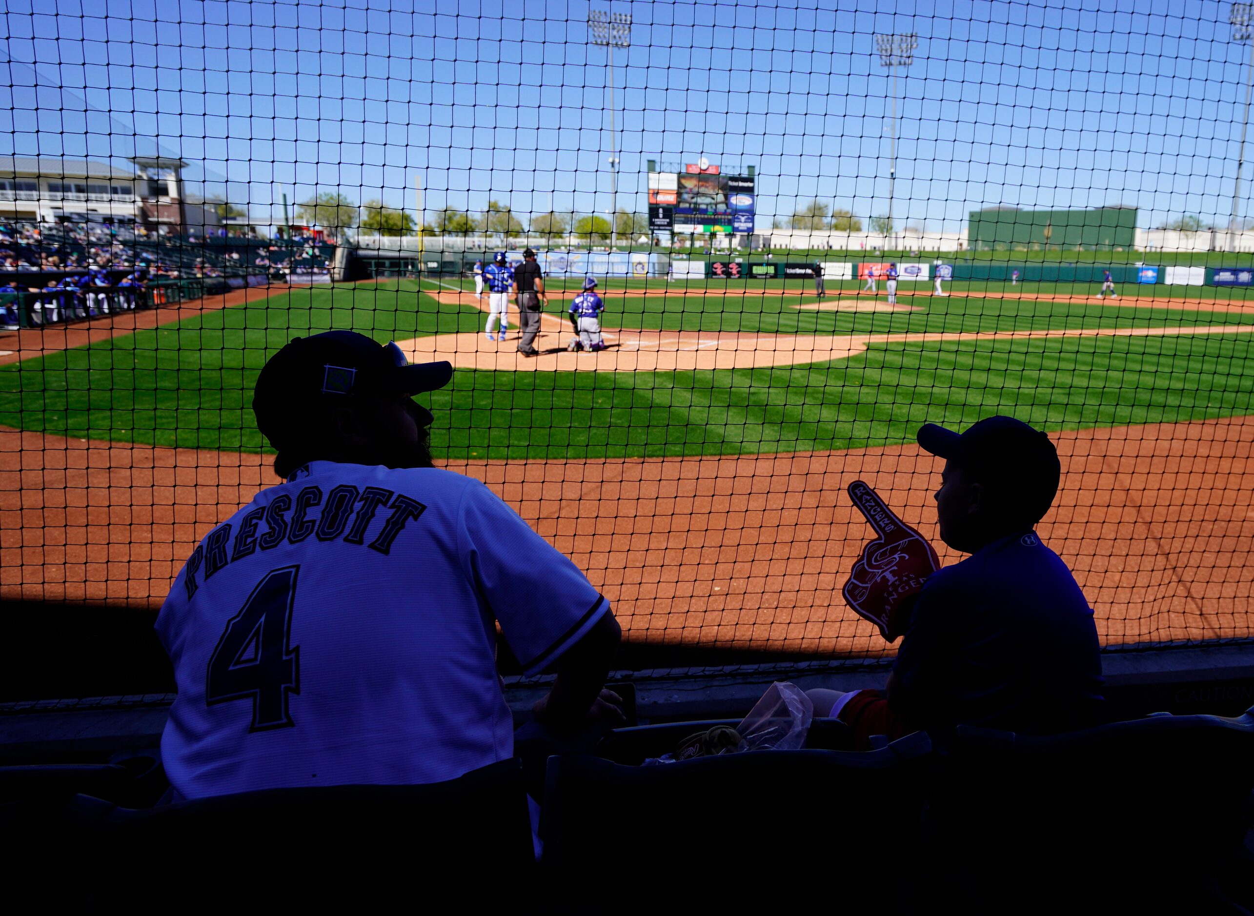 Texas Rangers’ fans Micael Dickerson (originally from Merkel TX) talks to his son Landry 10,...