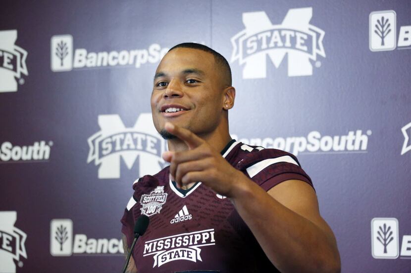 Mississippi State quarterback Dak Prescott smiles at a question from reporters about the...