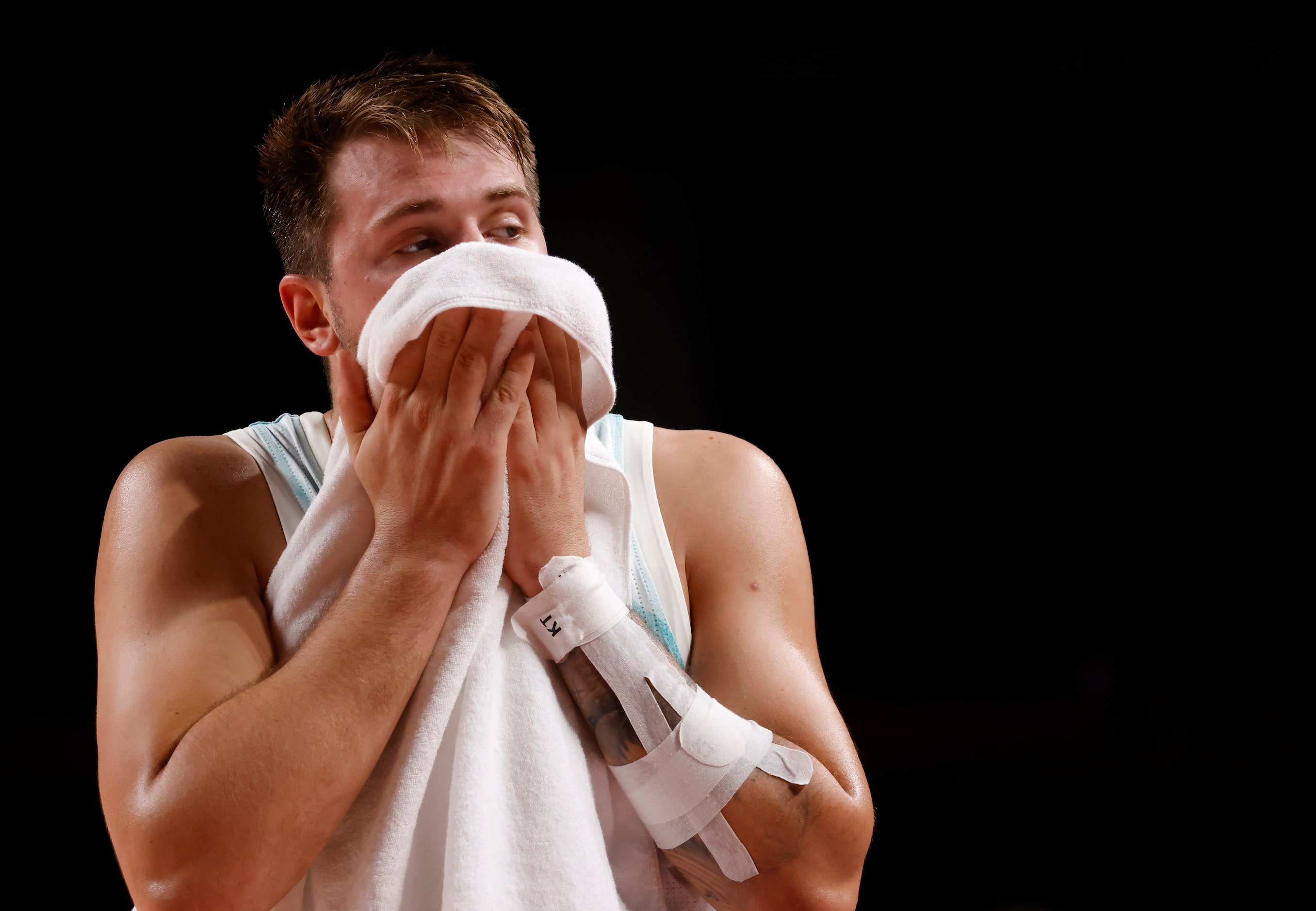 Slovenia’s Luka Doncic (77) wipes his face in a game against Australia during the third...