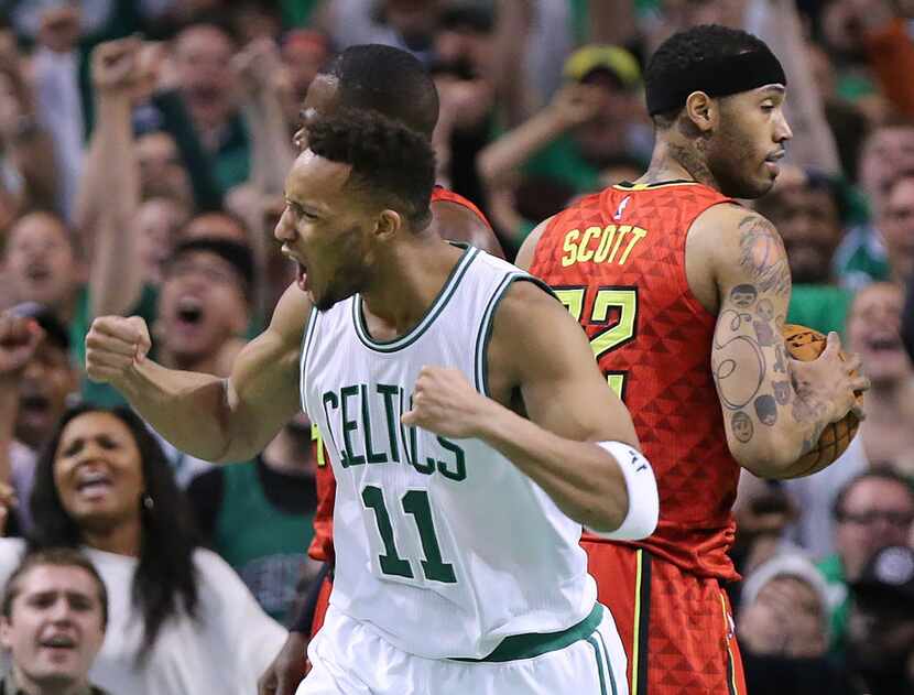 Boston Celtics' Evan Turner (11) reacts to scoring against the Atlanta Hawks while Mike...