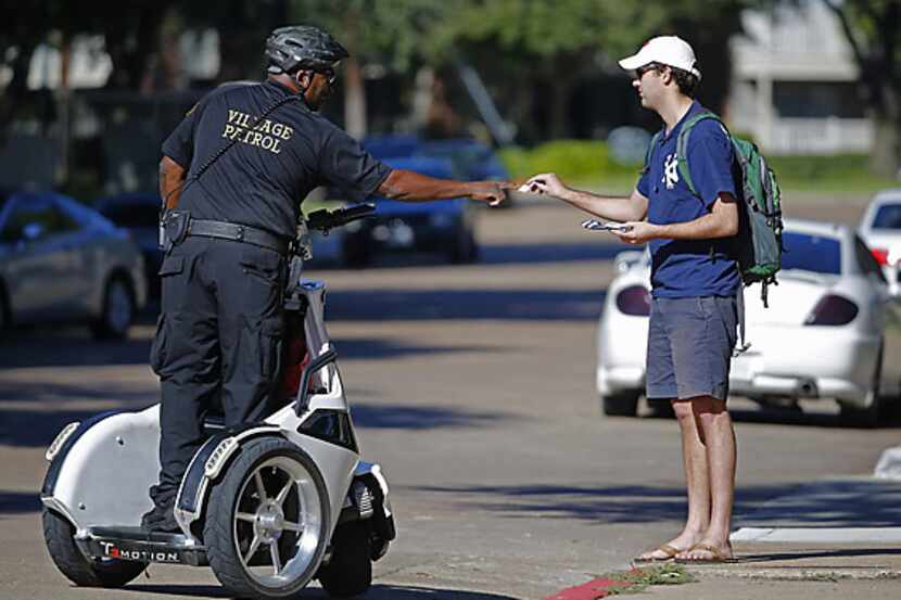 A security guard checks identification at The Village apartment complex in East Dallas