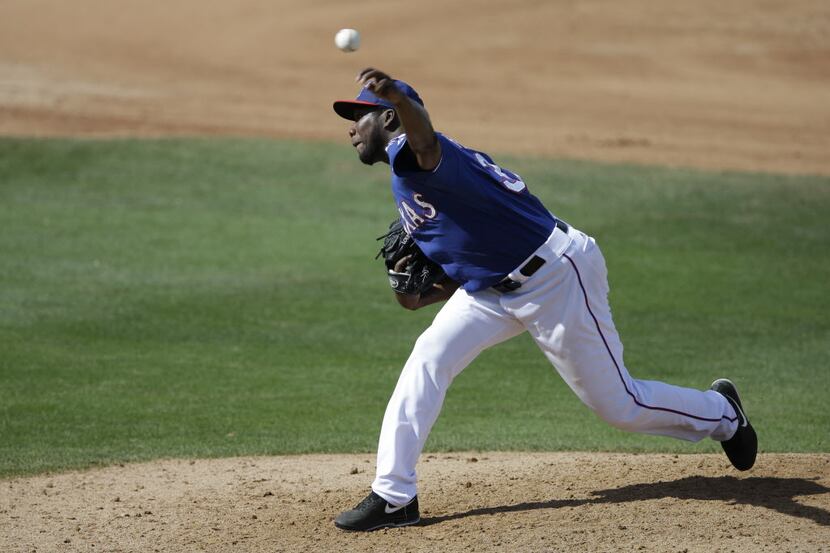 Texas Rangers relief pitcher Pedro Figueroa throws during a spring exhibition baseball game...