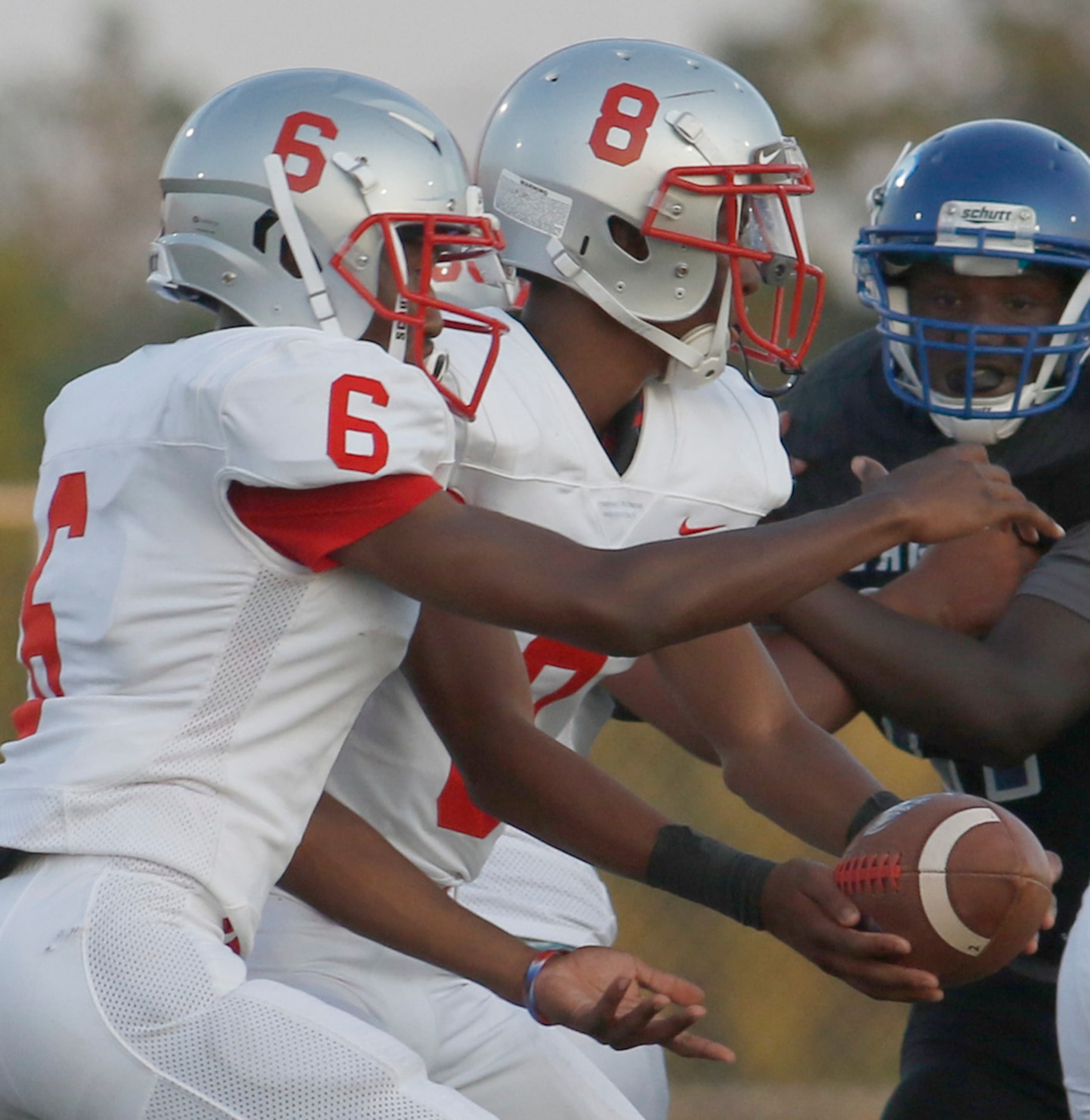 Spruce quarterback Damethis Davis (8) hands off to running back Adrian Wickware (6) during...