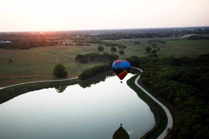 A balloon touches down over the water during a media flight before the Plano Balloon...