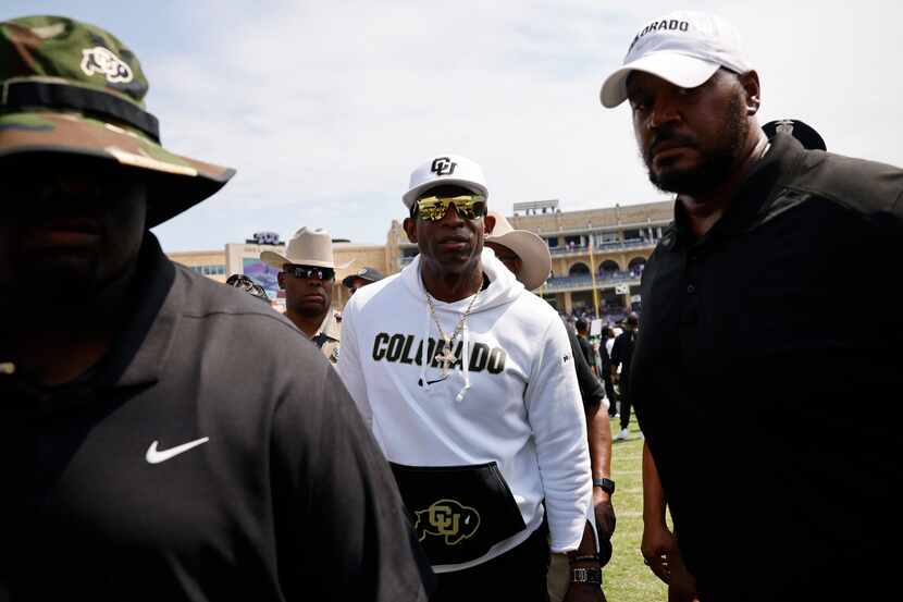 Colorado head coach Deion Sanders, center, leaves the filed after an NCAA college football...