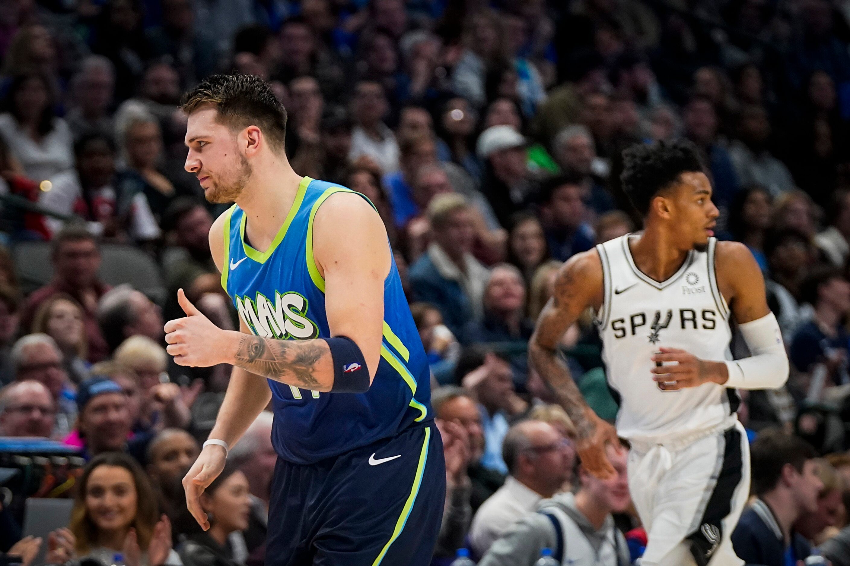 Dallas Mavericks guard Luka Doncic (77) gives a thumbs up to the bench after hitting a...