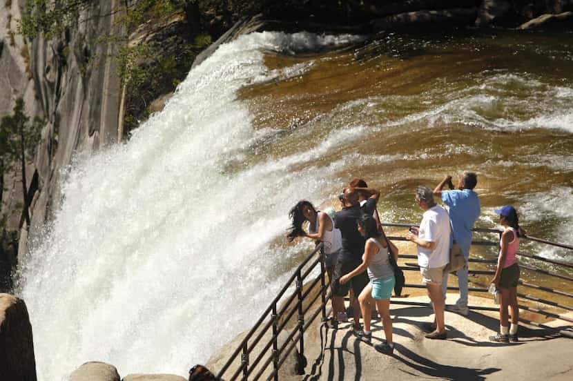 Visitors to Yosemite National Park stand behind the safety railing at the 317-foot Vernal Fall.