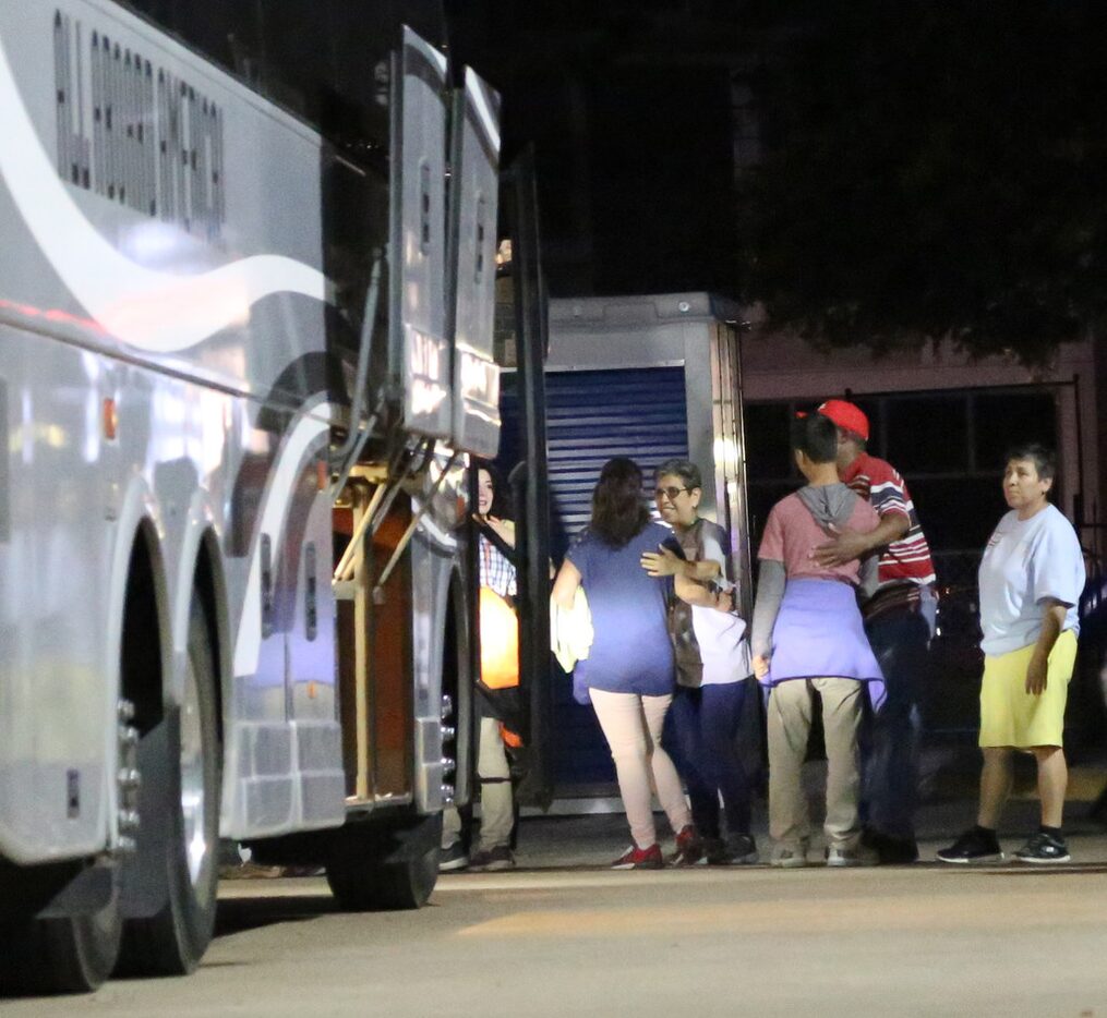 Organizers and volunteers greet migrants arriving from an El Paso migrant shelter at Oak...