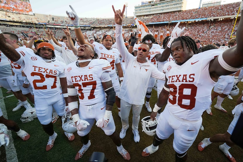 Texas head coach Steve Sarkisian celebrates with his players after a 34-3 victory over...