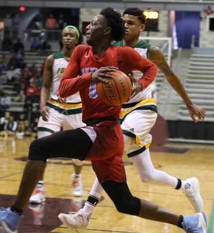 Dallas Skyline point guard Marcus Garrett (0) races down the baseline past two Klein Forest...