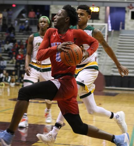 Dallas Skyline point guard Marcus Garrett (0) races down the baseline past two Klein Forest...