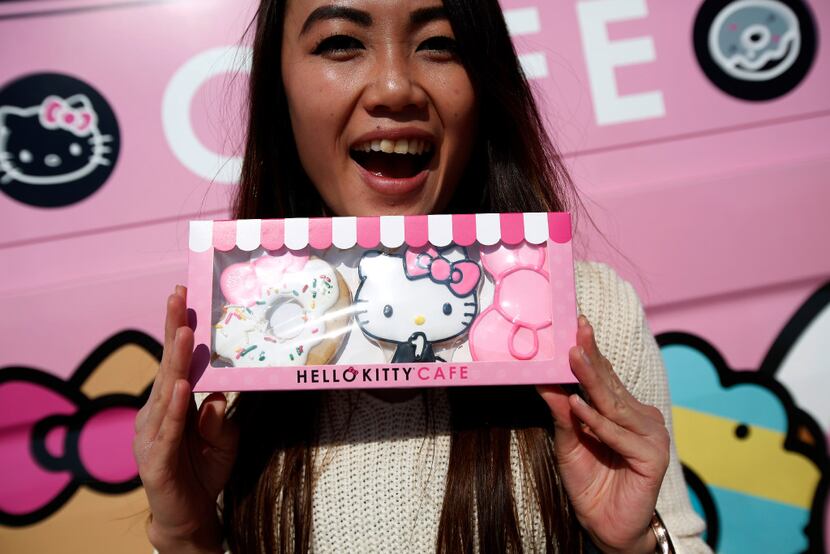 Ella Go holds a set of cookies in front of the Hello Kitty food truck at The Shops at Willow...