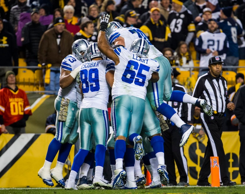 The Dallas Cowboys celebrates after running back Ezekiel Elliott (21) ran the ball to the...