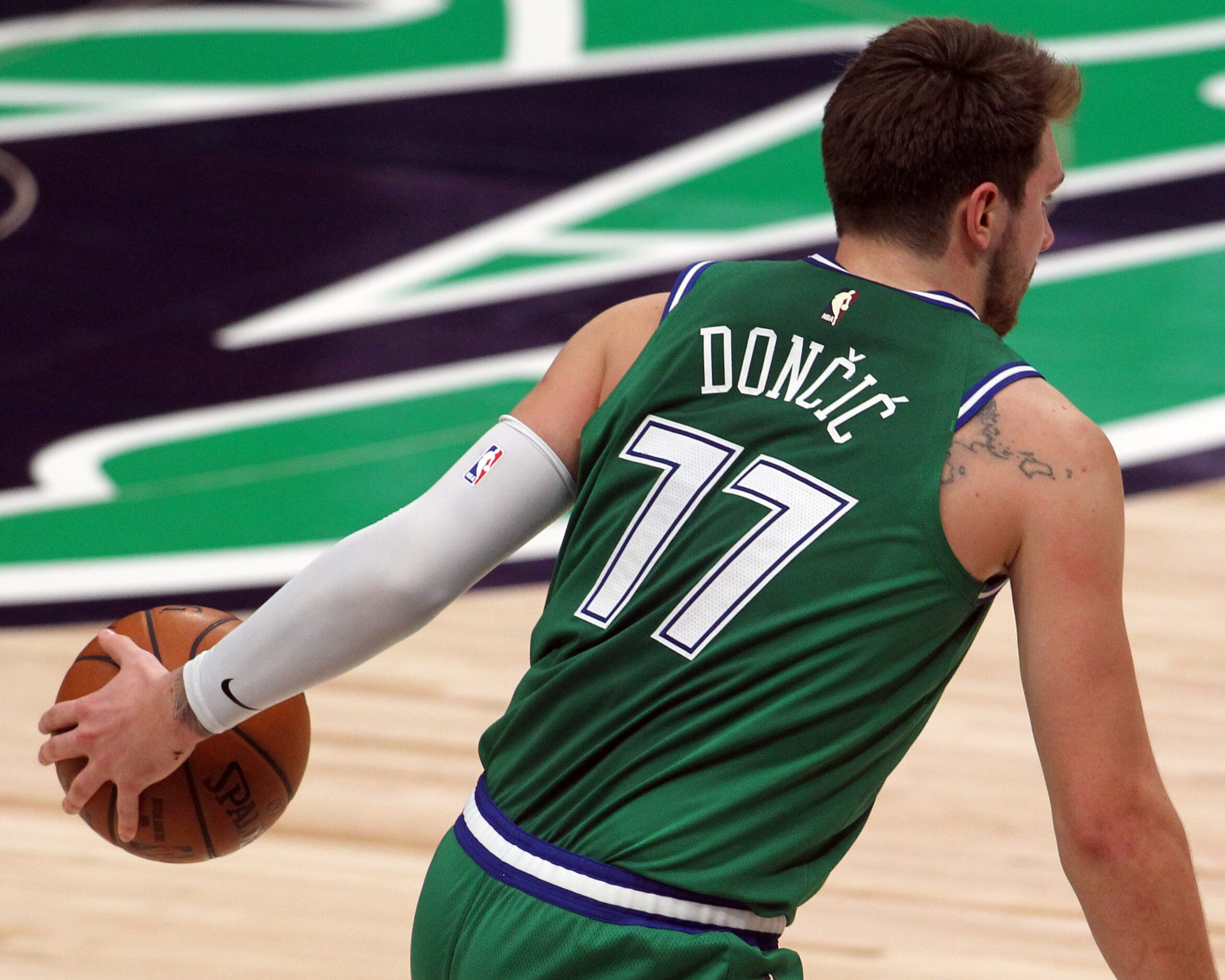 Dallas Mavericks point guard Luka Doncic (77) brings the ball past mid-court during the...