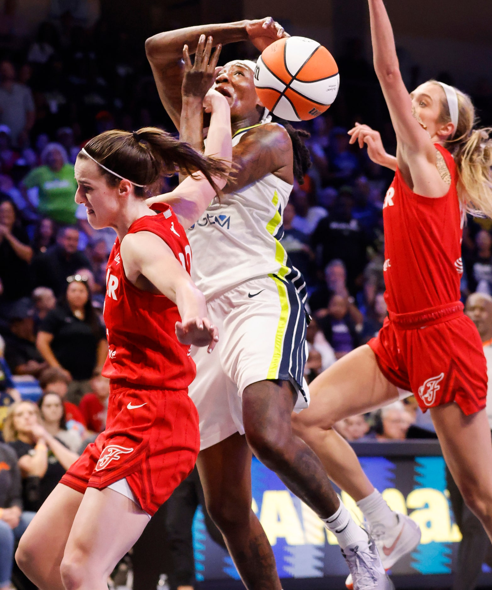 Dallas Wings forward Natasha Howard (6) is fouled by Indiana Fever guard Caitlin Clark (22)...