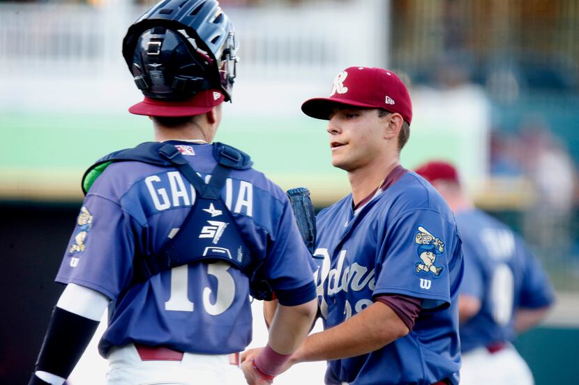 The RoughRiders starting pitcher Jack Leiter (22) is congratulated by catcher David Garcia...
