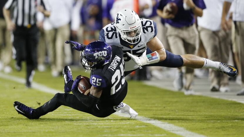 TCU Horned Frogs wide receiver KaVontae Turpin (25) is tackled by West Virginia Mountaineers...