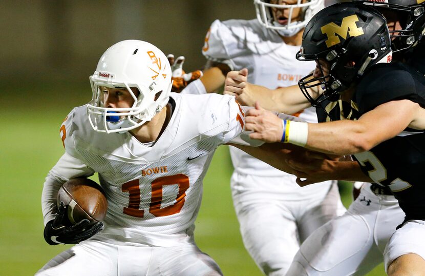 Mansfield Tigers defenders Corbin Frederick (2) and Jarrett  Skaggs (42) corral Bowie...