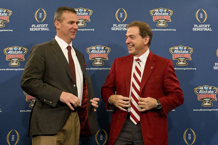 Ohio State coach Urban Meyer, left, and Alabama coach Nick Saban laugh during a press...