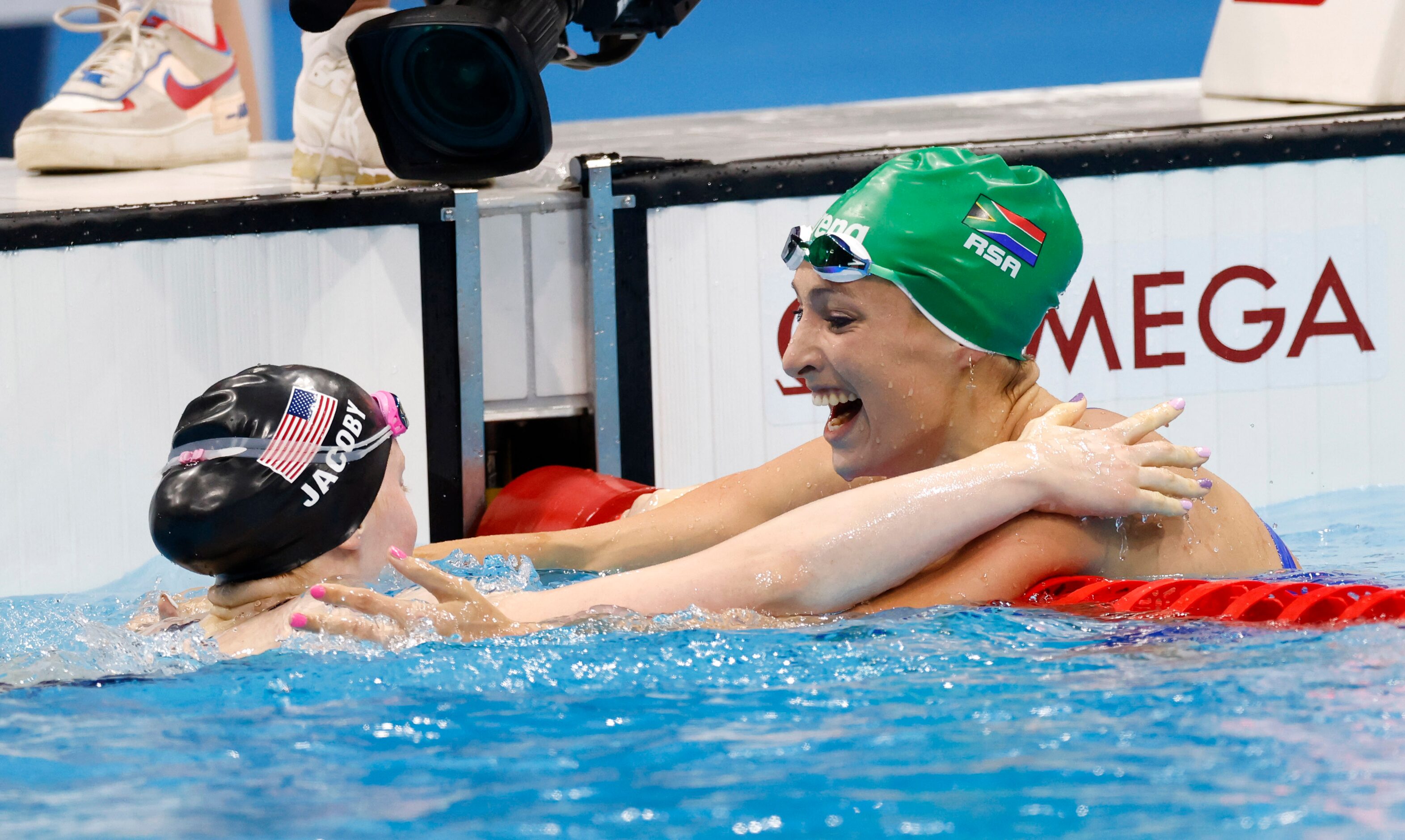 USA’s Lydia Jacoby and South Africa’s Tatjana Schoenmaker celebrate after finishing first...