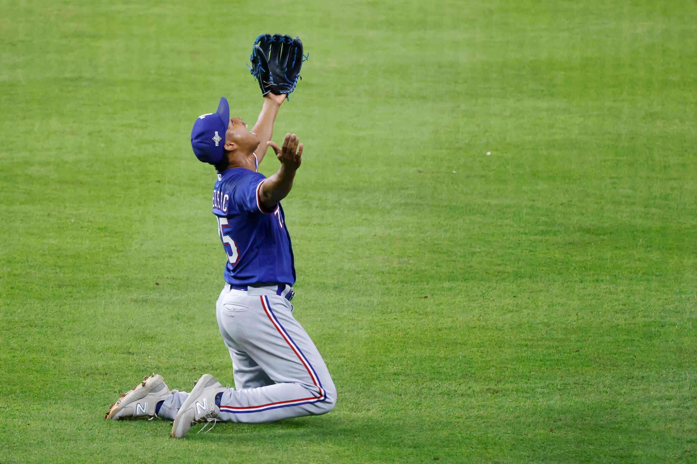 Texas Rangers relief pitcher Jose Leclerc drops to his knees after winning the American...