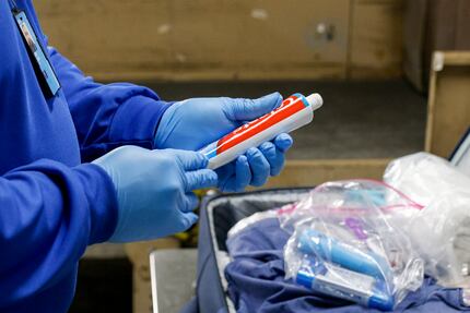 TSA lead transportation safety officer Andre McCain wipes a tube of toothpaste with a swab...