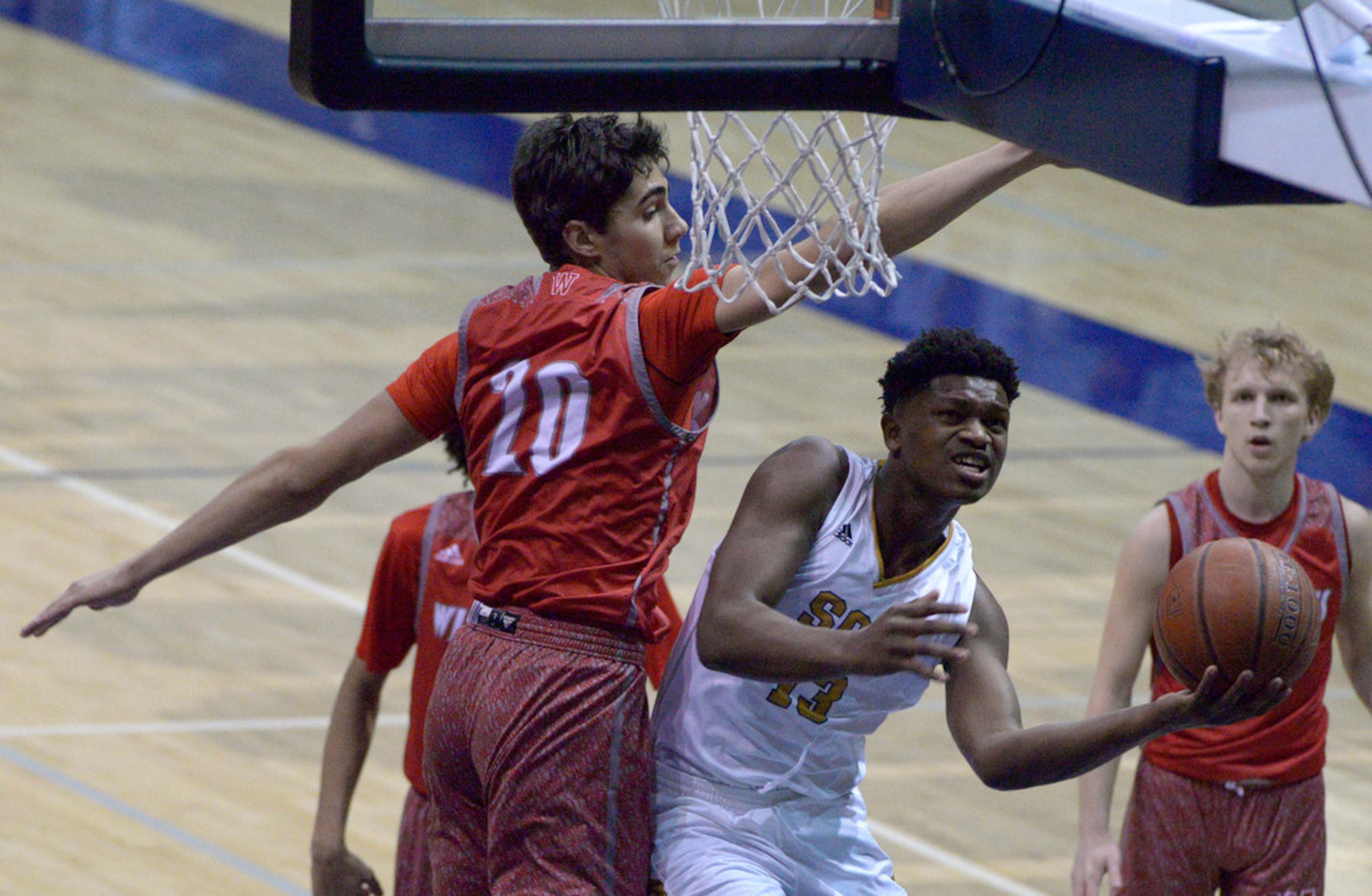 South Oak Cliff's Antonion Patterson tries to shoot around Woodrow Wilson's Beau Becker (20)...