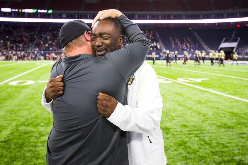 DeSoto assistant coach Brandon Harrison (right) hugs head coach Todd Peterman (back to...