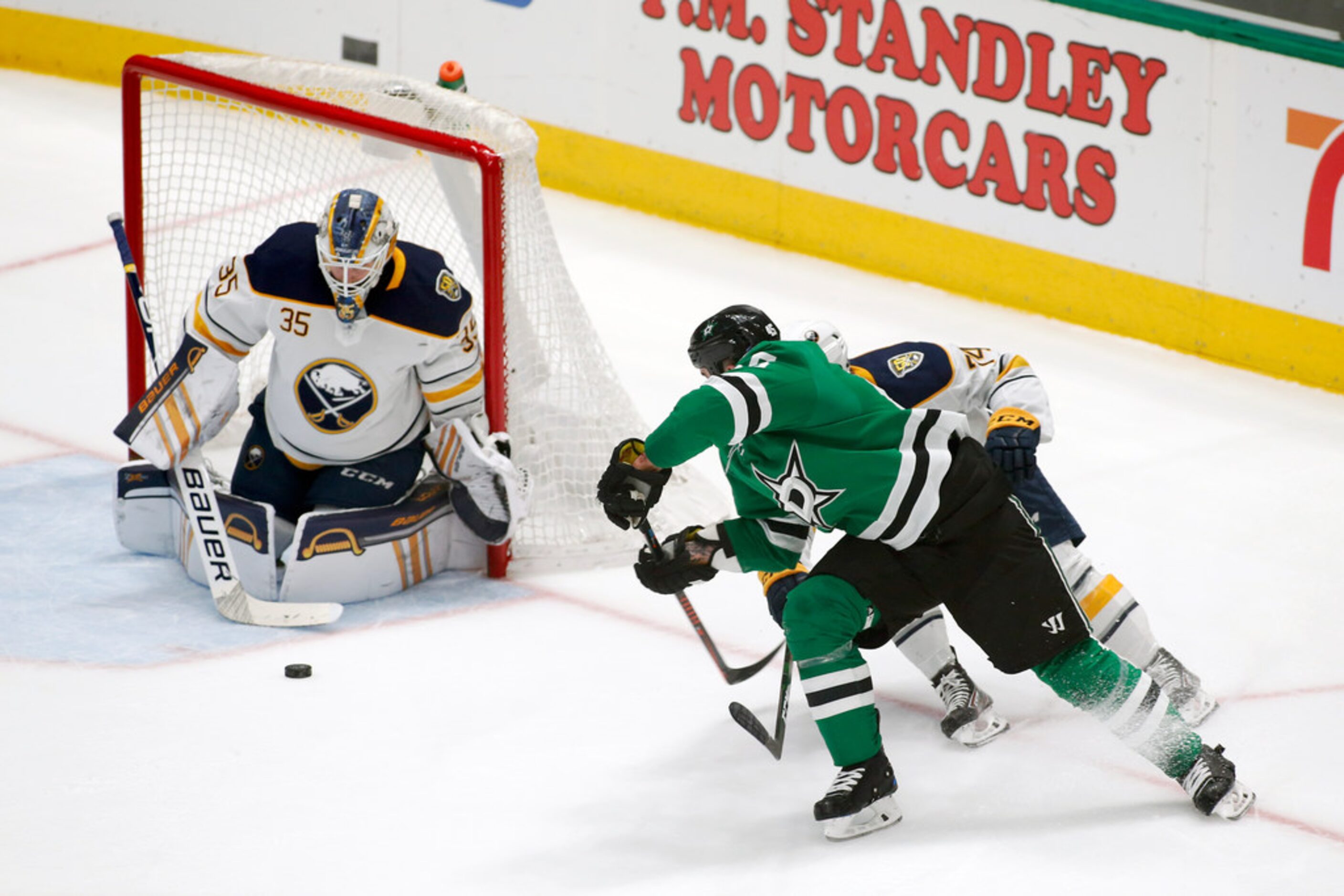 Buffalo Sabres goaltender Linus Ullmark, left, makes the save of the shot by Dallas Stars...