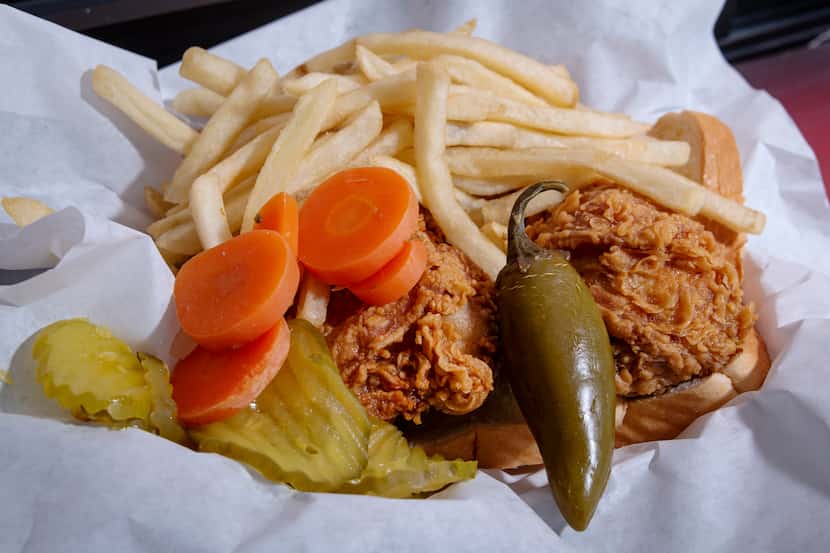 A two-piece dark chicken platter served with fries, pickles, carrots and a jalapeño from...