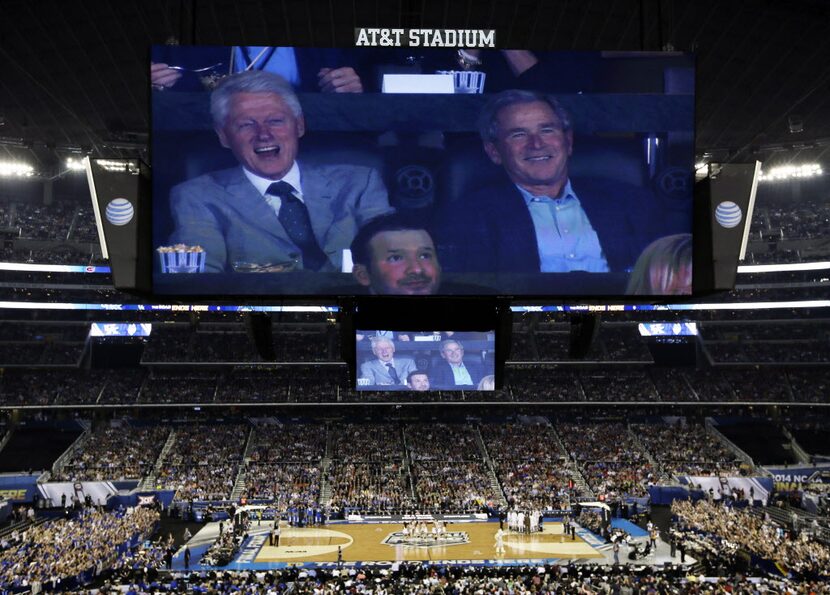 Former presidents Bill Clinton, left, and George W. Bush watch action between Connecticut...