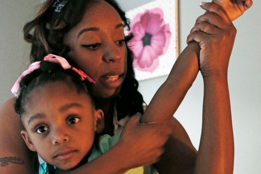 
Ora Lee gives her daughter, Kennedy, 3, a massage during a therapy session at First Peek...