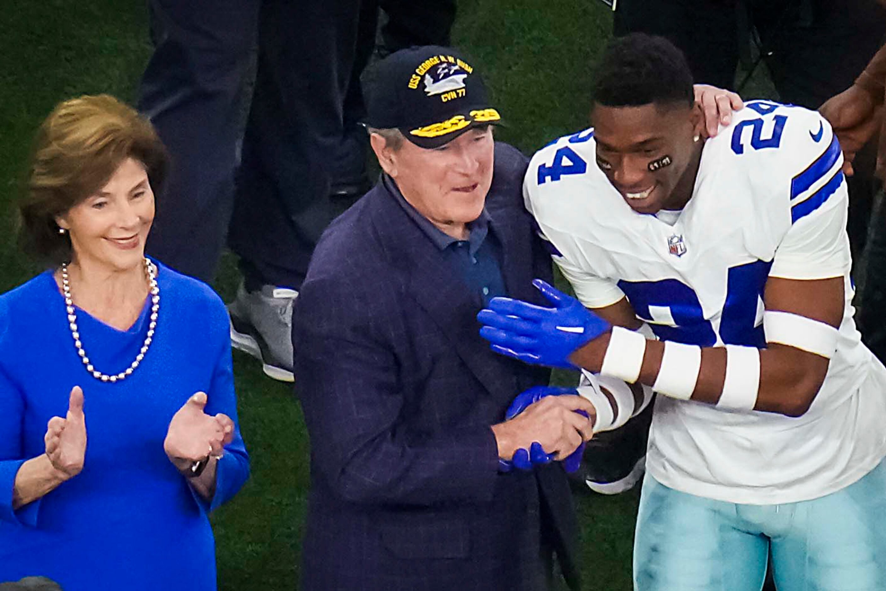 Former President George W. Bush shakes hands with Dallas Cowboys safety Israel Mukuamu...